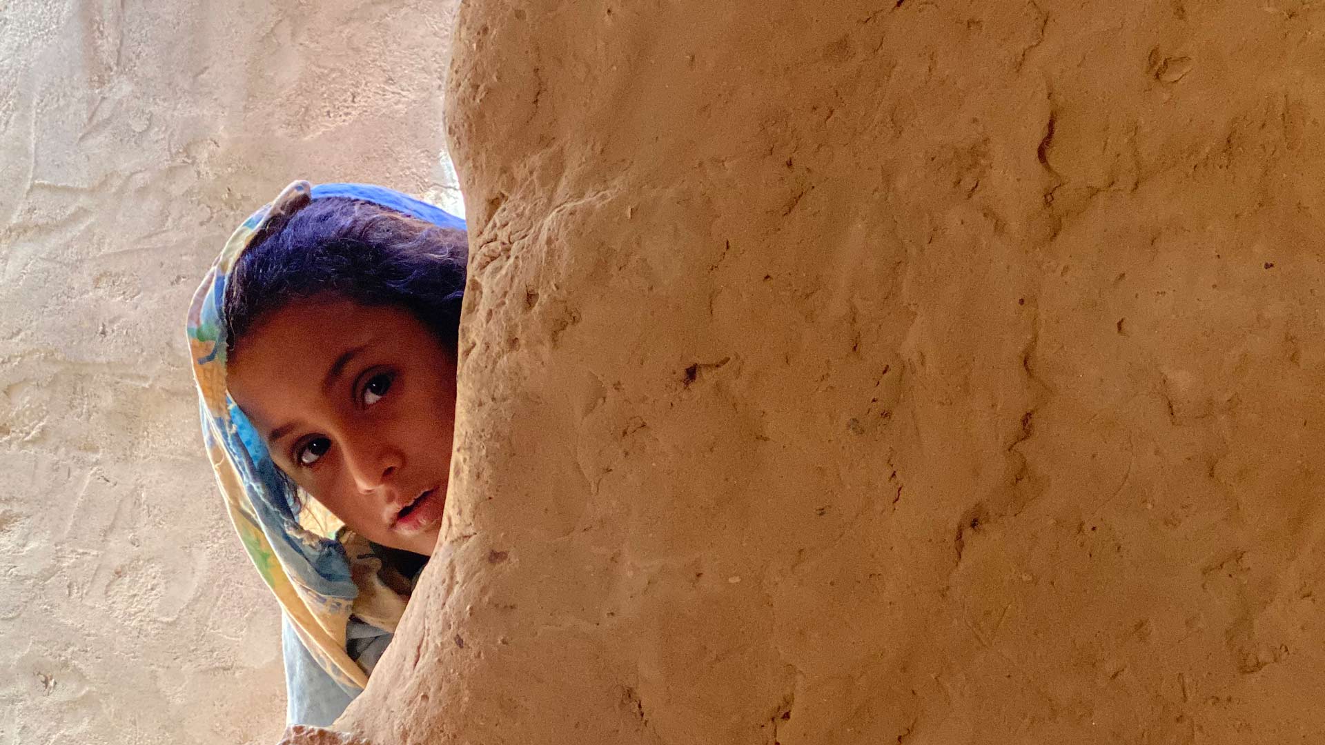 A young girl prepares for school from her mud home in one of 83 hosting sites for internally displaced Yemenis in Marib. March 2020, UNHCR/Marie-Joëlle Jean Charles